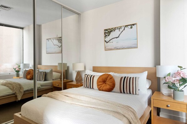 The master bedroom with a queen sized bed & plush pillows.