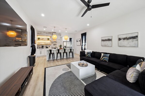 Living into Kitchen- wall mounted smart HDTV w/ streaming services, modern decor