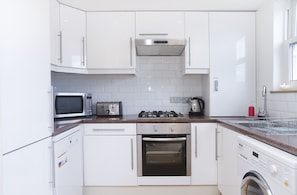 Kitchen with Gas hob, washing machine, microwave