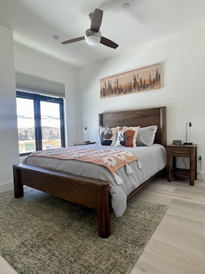 Relax in Style with Wood Furnishings, Ceiling Fan, and Smart TV in your bedroom