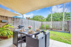 The private, fully fenced backyard is the perfect spot to relax, featuring a dining table for al fresco meals and a BBQ for outdoor cooking. Enjoy the tranquility and privacy of this charming outdoor space.