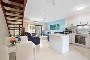 The house is spread across two levels for added space and comfort. On the ground floor, you'll find the fully equipped kitchen, cozy living room, private garden and patio, a half bathroom, and a laundry area. The first floor features two spacious bedrooms