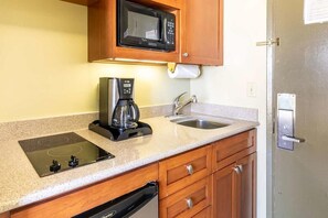 Kitchenette with a microwave, stove, oven and fridge.