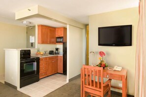 Kitchenette with a microwave, stove, oven and fridge.