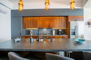 The fully-equipped kitchen amenities include a full-size fridge, stove, oven and dishwasher