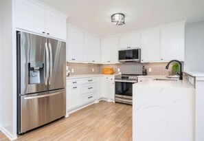 The modern kitchen boasts sleek stainless steel appliances and a spacious layout, making meal preparation a breeze.