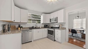 Spacious modern kitchen with fridge, oven, microwave, dishwasher, coffee bar and spice rack!