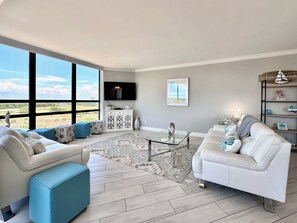 Living room with plenty of natural light, panoramic windows and new leather furniture.