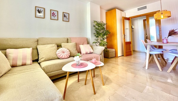 Living room with sea views, large sofa, and dining table. Perfect for relaxing and enjoying your vacation.