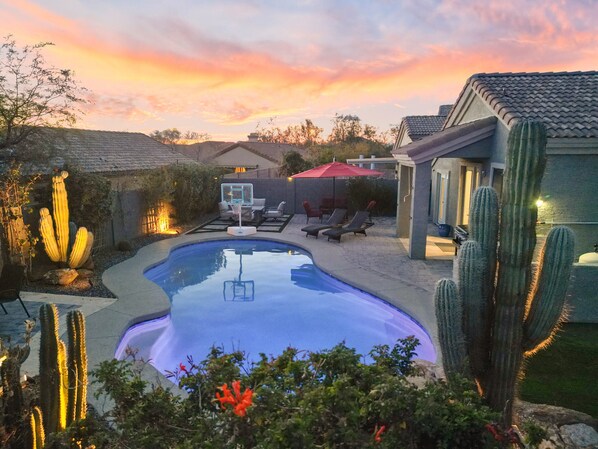Gorgeous backyard with many seating areas, grill, and turf side yard.