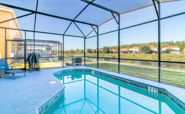 Screened private pool with sun loungers and serene lake views.
