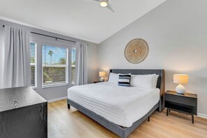 Spacious Primary 2nd-floor bedroom with King size bed, 6-drawer dresser, large smart TV, and walk-in closet