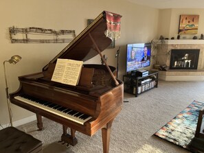 Living room with Steinway grand piano and 55" smart TV.