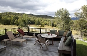 View from just outside screened in porch looking at deck and out over mountains