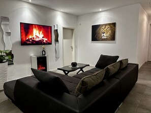 Wohnzimmer mit Ecksofa,Flatscreen mit Fire-TV-Stick & einem elektronischem Kamin