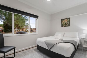 Sleep easy in the first bedroom. It features a queen-sized bed, topped in crisp white linens for your stay.
