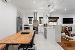 The kitchen and dining area are open plan with a large timber table where you can sit and share a meal.
