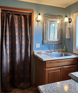 Kitchen sink and curtain to laundry area and apartment entrance.