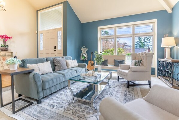 Step into the living room, where charming country-style furniture harmonizes with a vaulted ceiling, creating an inviting ambiance that exudes warmth and elegance