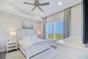 A spacious bedroom with large windows, inviting in the morning sunshine.