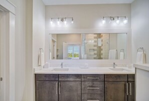 A welcoming bathroom with rich wooden cabinetry and a dual-sink vanity.