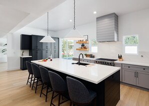 Fully Equipped Kitchen boasting brand-new stainless-steel appliances, ample cabinet / pantry storage and an oversized island offering ample counter space and bar seating.