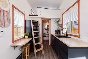 The dining area features a tabletop shelf, perfect for compact spaces. Paired with seating, it’s a functional and space-saving solution for meals or work.