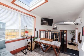 Relax in the inviting living room featuring a comfortable couch and a TV for entertainment. A sofa bed provides extra sleeping space, and with Wi-Fi access, this space is perfect for unwinding or enjoying your favorite shows and movies.