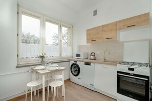 A fully equipped kitchen with wooden accents, a washing machine, and a dining area, ensuring both style and functionality.

