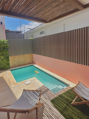 Two lounge chairs and a customized wood pergola to enhance shade and privacy.