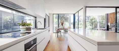 Cook up a feast in the sleek white kitchen. It’s fully equipped for your holiday catering.