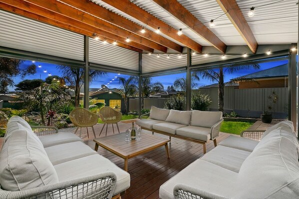 A cosy lounge setting on the undercover deck offers an idyllic spot to sip your morning cuppa or cheers with a glass of wine come evening.