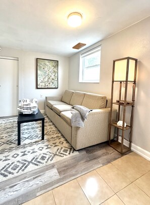 Living room features queen size sofa bed and a TV.