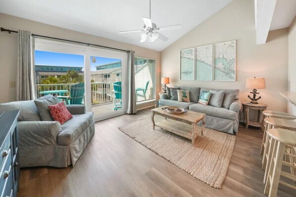 Spacious living room with large beautiful windows over looking the heated pool.
