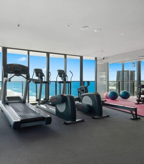 Indulge in a fully equipped gym located on a higher floor, allowing you to work out while enjoying a breathtaking 180-degree view of the ocean.