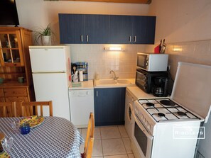 Fully equipped kitchen with dining table, TV, armchair and air conditioning