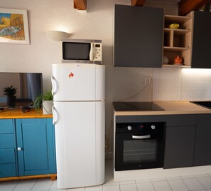Kitchen with oven, toaster, coffee machine, fridge and freezer.