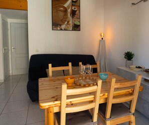 Air-conditioned living room with kitchen, sofa and dining area