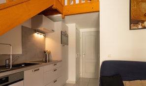 Air-conditioned living room with kitchen, sofa and dining area