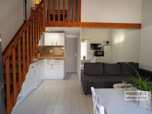 Living room with sofa and TV, opening onto terrace