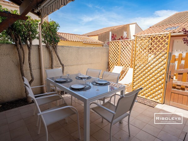Intimate terrace with dining area, deckchairs and charcoal barbecue