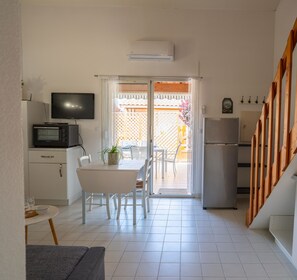 Kitchen opening onto living room. With coffee machine, toaster, oven etc.