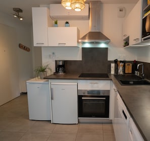 Fully equipped kitchen with oven, dishwasher and washing machine.