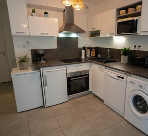 Fully equipped kitchen with oven, dishwasher and washing machine.