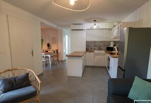 Grande pièce de vie climatisée avec cuisine ouverte et wifi