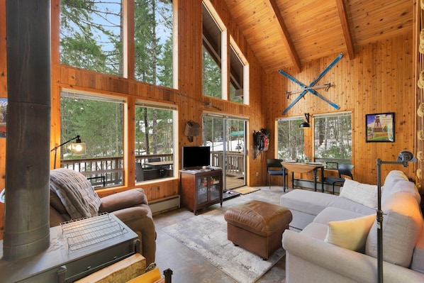 Large A-Frame style windows looking out to the wooded lot.