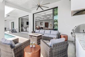 Poolside lanai with a built in grill and free standing fire table 