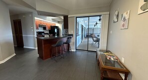 Kitchen features essential appliances. It also has a counter with 2 bar stools.