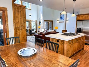 Cook and connect in this open-concept kitchen, complete with modern appliances, a large island with bar seating, and views of the serene forest surroundings