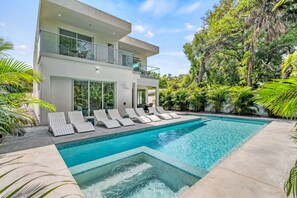 Private Heated Pool with spa area and bank of poolside chaise lounges.  Spa section of pool shown